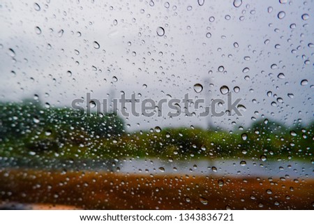drops on glass. rain water drop on the windows of car with blur road and forest in the morning. water drops on glass 