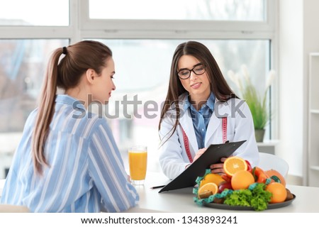 Young woman visiting nutritionist in weight loss clinic Royalty-Free Stock Photo #1343893241