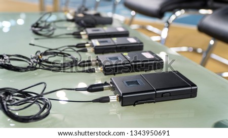 wireless microphone transmitter and wireless microphone reciever on glass table in tv studio