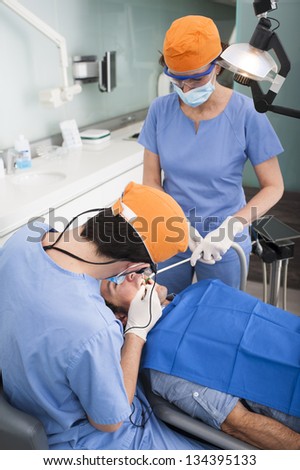Professional dentist doing teeth checkup on female patient