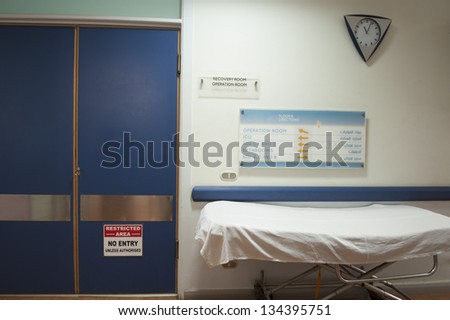 Hospital gurney outside an operating room with a clock