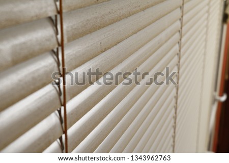 dirty window blinds covered with dust