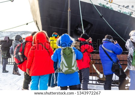 The world first nuclear icebreaker Lenin. A crowd of Chinese tourists takes a picture of the ship. The Northern city of port Murmansk.