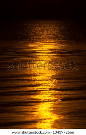 Abstract gold wave on the dark water with sunlight.