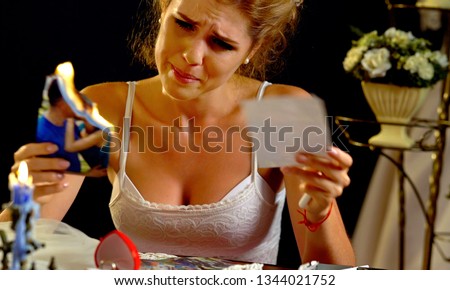 Woman in psychological stress after breaking up. Girl burns wedding photos from family photo album.