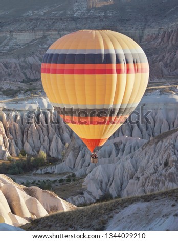 Hot air balloon flying into a canyon.