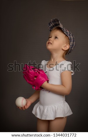 Little pretty girl in white dress plays baseball