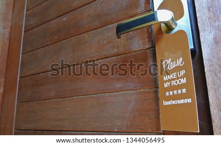 Door knob with label on a door handle. Leaflet design on entrance doorknob. Don't disturb sign and make up room.