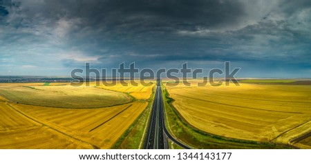 Aerial view of a beautiful highway motorway road in Romania through agriculture fields