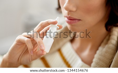 rhinitis, medicine and healthcare concept - close up of sick woman using nasal spray Royalty-Free Stock Photo #1344154676