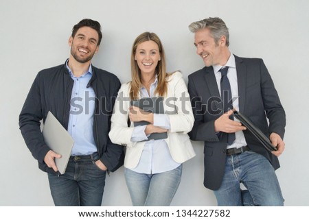 Happy sales team standing together on grey background