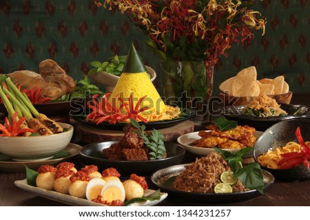 Nasi Tumpeng Nusantara. The elaborate Indonesian rijsttafel of yellow rice with seven side dishes from several regional cuisines in the country. Royalty-Free Stock Photo #1344231257