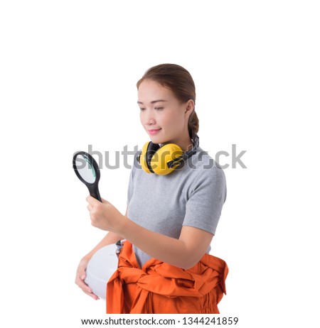 portrait of a woman worker in Mechanic Jumpsuit with helmet and earmuffs. hand holding Magnifying glass isolated on white background clipping path