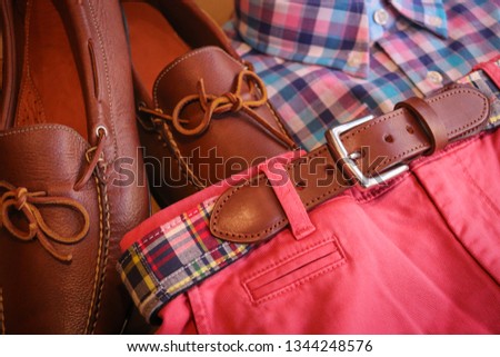 A preppy men's outfit for the summer / spring time. The matching leather shoes and belt compliment the salmon pink shorts and checkered shirt.