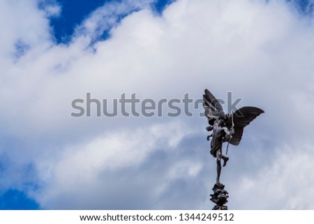 Eros Statue, Piccadilly Circus, London History on blue sky and white clouds background.