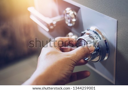 Close up of a man hand hold and tuning on a combinations safe dial lock Royalty-Free Stock Photo #1344259001