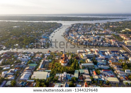 Aerial view of the famous Cai Be church in the Mekong Delta, Roman architectural style. In front is Cai Be floating market on Tien Giang river, Vietnam