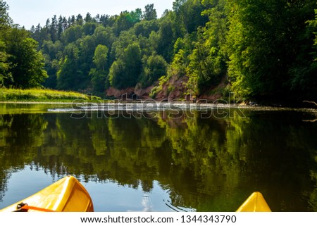 Kayak and canoe ride in river Gauja in Latvia. Boat ride by the river. Beautiful view of river from boat. The Gauja is the longest river in Latvia, which is located only in the territory of Latvia. 
