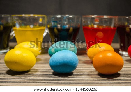 Transparent glass cups with water mixed with dry color. The process of coloring easter eggs concept. Happy Easter background.