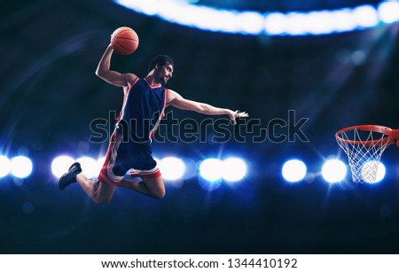 Acrobatic slam dunk of a basket player in the basket at the stadium