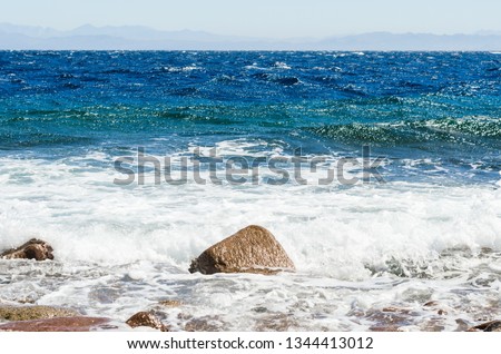 waves and splashes of sea surf and stones on the seashore