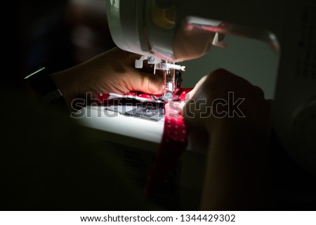 Hands on sewing machine. People are sewing on sewing machines.