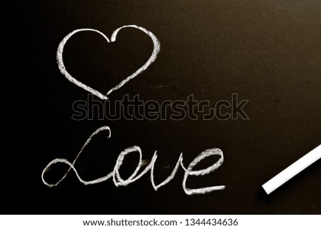 A chalk board with the word love and a heart. Grunge background texture