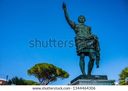 Roman emperor bronze statue on blue sky background in Naples