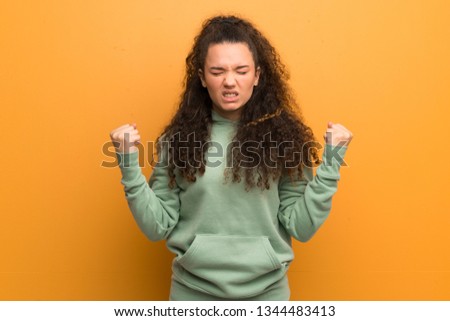 Teenager girl over ocher wall frustrated by a bad situation