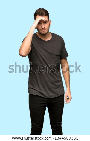 Man with black shirt looking far away with hand to look something over blue background