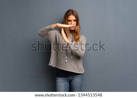 Blonde woman over grey background making time out gesture