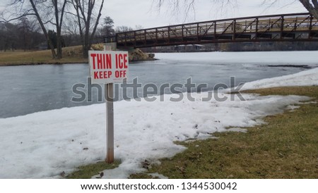 Thin Ice Sign Posted Near Bridge Over Frozen Lagoon