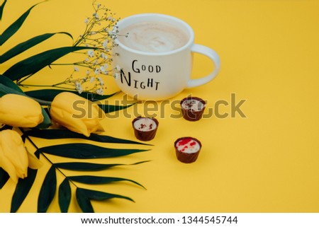 Coffee mug with yellow tulip flowers and chocolate good morning on yellow , breakfast on Mothers day or Womens day