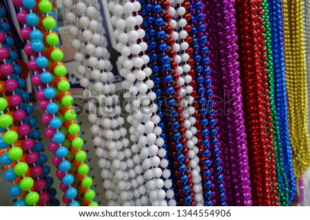 rainbow of hanging strands of bright multi colored plastic beads