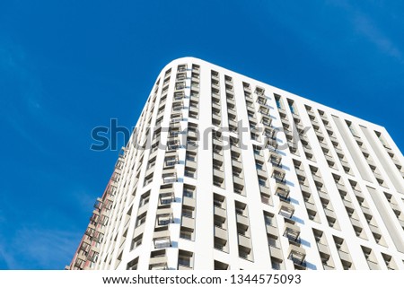Modern new multi-storey residential building against the blue sky. business card concept
