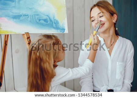 Beautiful little girl painting. Mother drawing with little girl.