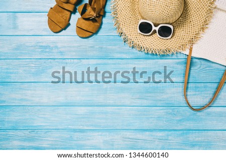 Top view of blue planks marine pier near the beach. Frame composition with summer accessories. Background with copy space and visible wood texture. Border composition
