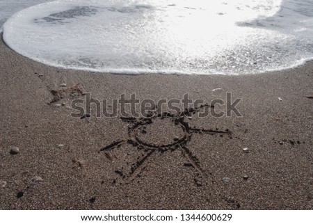 Sun in the wet sand on the beach painted with wave. Sand surface with sun
