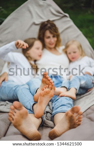 mother with children having fun in a hammock. Mom and kids in a hammock. The family spends time with the children in the garden.