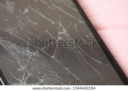 Broken mobile phone on a pink wooden background. Repair of mobile phone