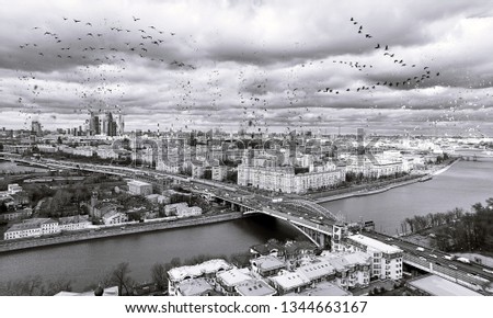 Dissolving pattern of monochrome aerial panoramic view of sunset above Moscow city with traveling boats under cloudy dramatic sky in spring