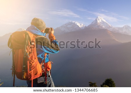 backpacker, single man, photographer, travel, standing and taking pictures of iceberg peaks in trekking Happy trekking at Annapurna Base Camp Nepal on vacation