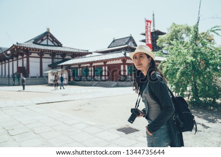 japan tourist female visiting attraction shitennoji temple taking photo picture at famous landmark. Asia travel sightseeing shinto shrine. elegant asian woman smiling carry camera looking around.