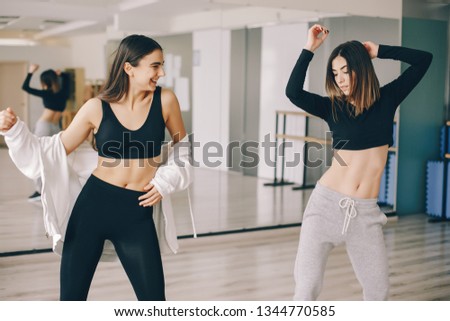 two beautiful slender girls doing dancing and gymnastics in the dance hall