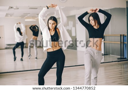 two beautiful slender girls doing dancing and gymnastics in the dance hall