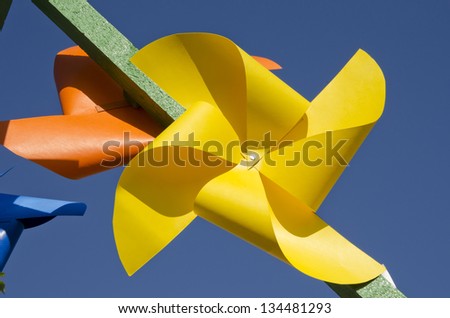 yellow paper windmill toy on blue sky background