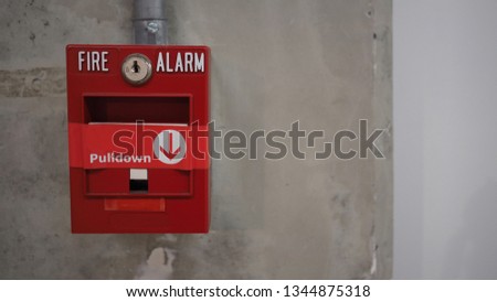 Emergency of Fire alarm or alert or bell warning equipment in red color with hand in the building for safety. 