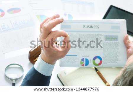 Businessman exploring fresh good news and gets great result, happy of it and makong OK sign