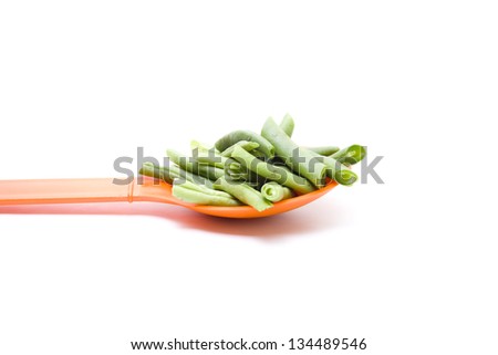 Green String beans on orange spoon