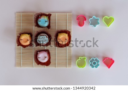 Bakery and cookie mold., Fancy donuts for birthday., On a light pink background and bamboo sushi rolling mat.
